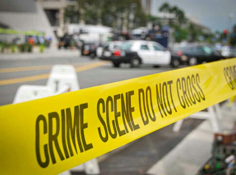 Yellow Crime Scene Do Not Cross tape across street.