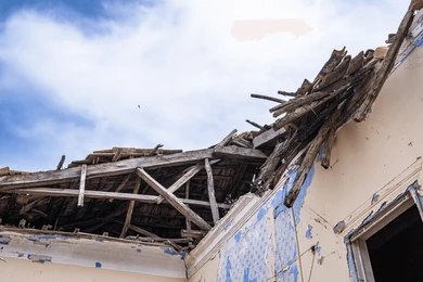People navigate rubble and collapsed concrete in a disaster scene