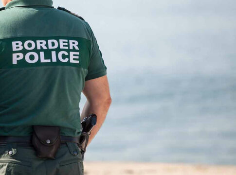 Border police officer standing near water.