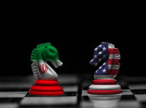 Chess knights with Iran and USA flags facing each other on a board