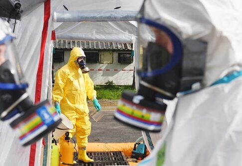 Emergency responders in hazmat suits preparing for a situation